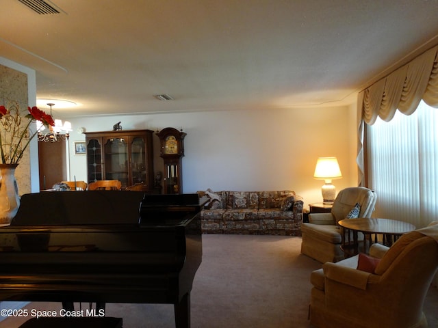 living room featuring a notable chandelier and carpet floors