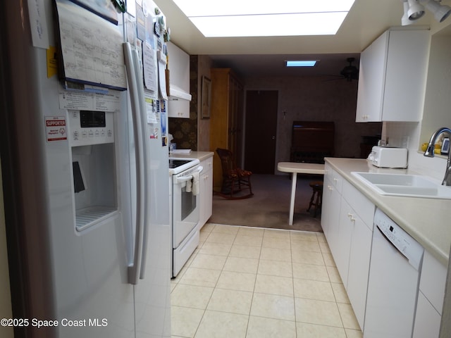 kitchen with white cabinets, white appliances, sink, and light carpet