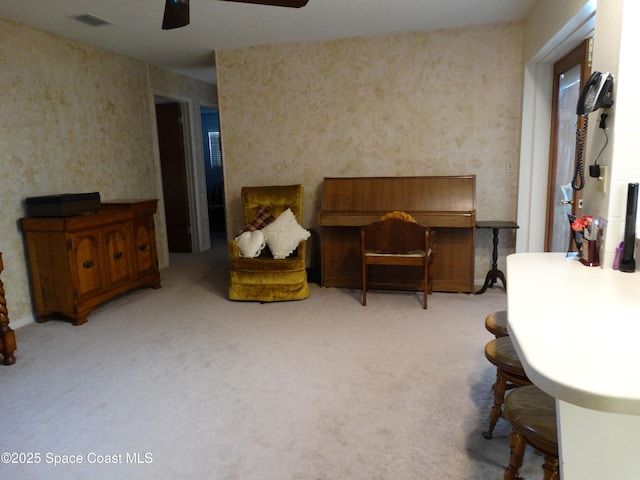 sitting room with ceiling fan and light colored carpet