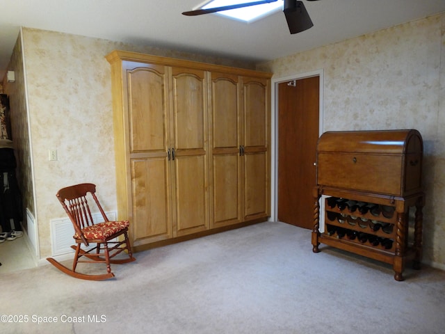 living area featuring ceiling fan and light carpet