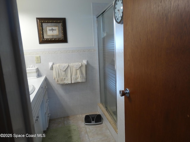 bathroom with vanity, tile patterned floors, walk in shower, and tile walls