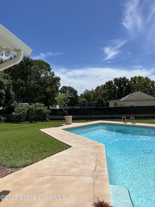 view of swimming pool with a lawn