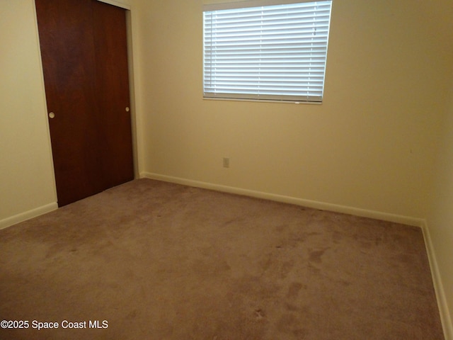 unfurnished bedroom with carpet flooring and a closet