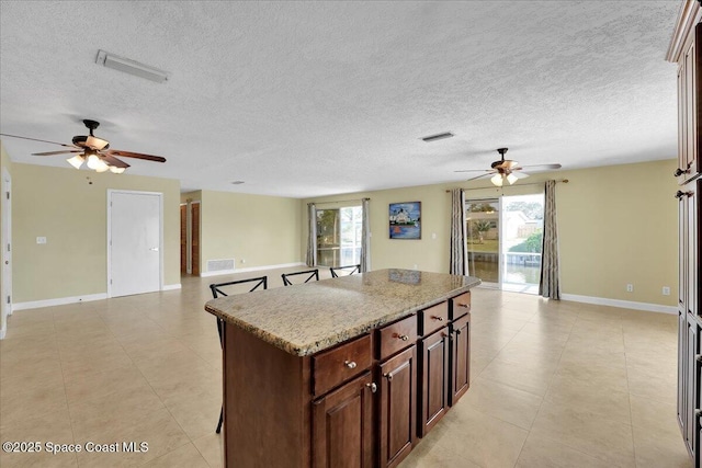 kitchen with ceiling fan, a center island, and a breakfast bar area