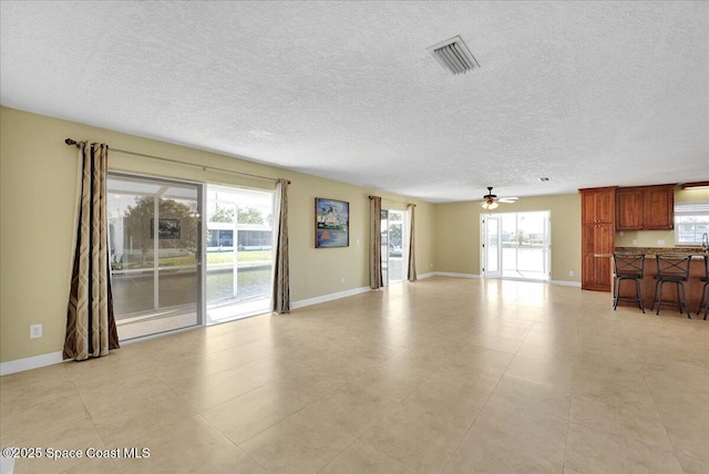 unfurnished living room featuring ceiling fan