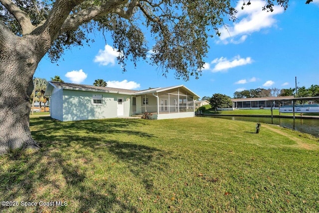 back of house with a lawn and a sunroom