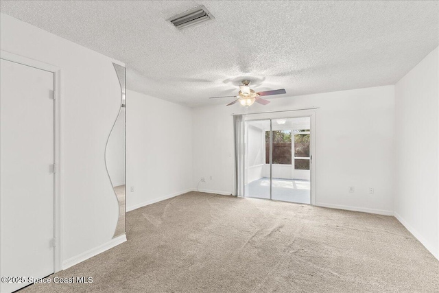 unfurnished room featuring carpet flooring, ceiling fan, and a textured ceiling