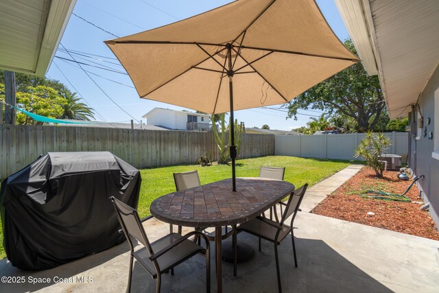 346 Cyprus Dr, Cocoa Beach, FL 32931 - fenced backyard featuring a grill, outdoor dining space, and a patio