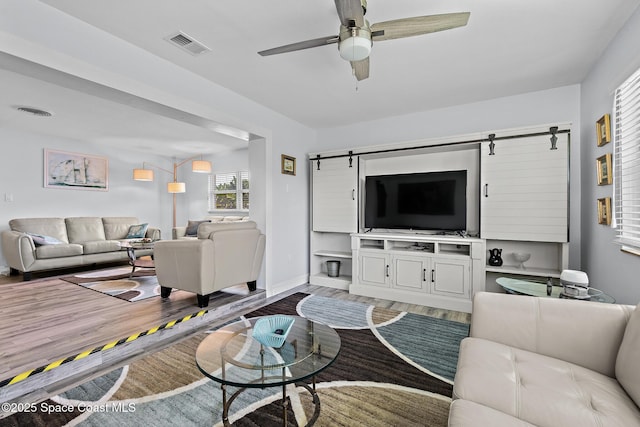 346 Cyprus Dr, Cocoa Beach, FL 32931 - living room with a barn door, wood finished floors, and a ceiling fan