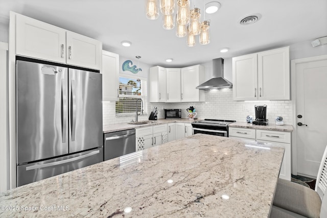 346 Cyprus Dr, Cocoa Beach, FL 32931 - kitchen featuring stainless steel appliances, wall chimney range hood, decorative backsplash, and white cabinets