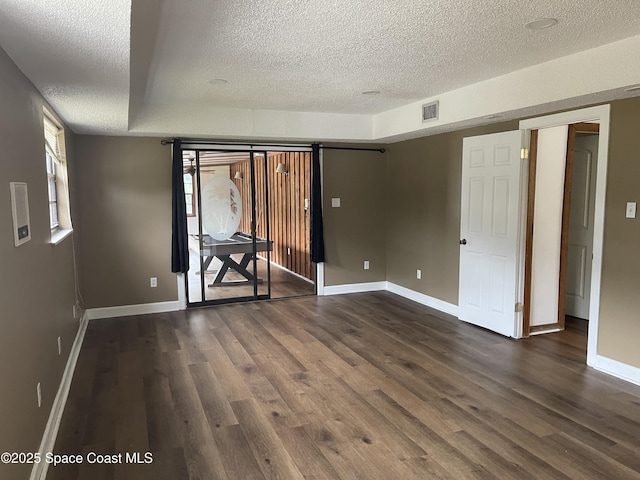 unfurnished room with dark hardwood / wood-style flooring and a textured ceiling