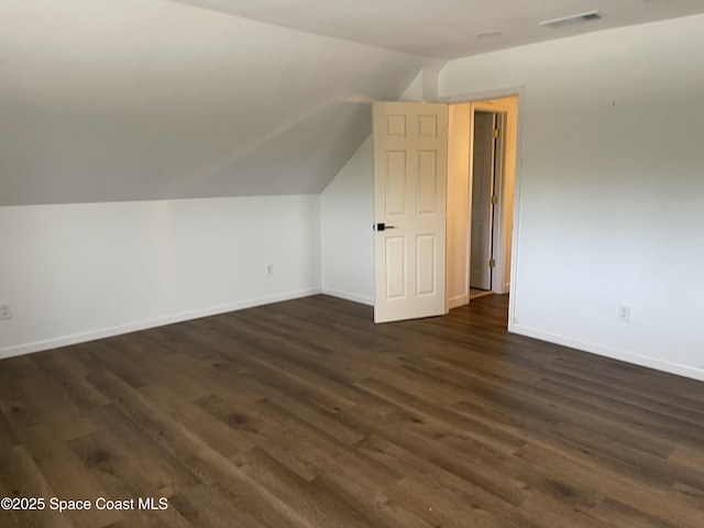 additional living space featuring dark hardwood / wood-style flooring and lofted ceiling