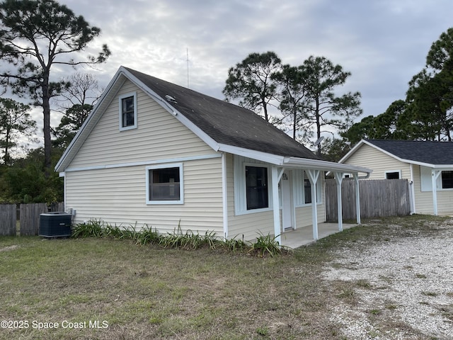 view of property exterior with a yard and central AC