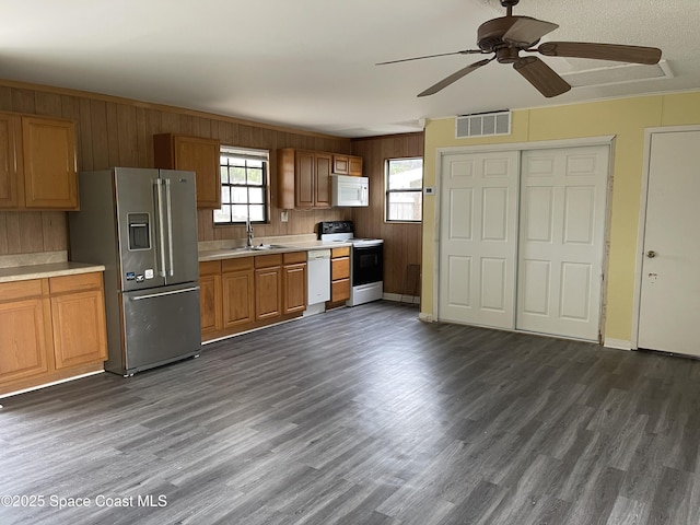 kitchen featuring white appliances, dark hardwood / wood-style floors, ceiling fan, and sink