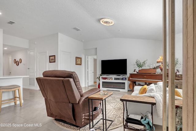 living room with vaulted ceiling, light tile patterned floors, and a textured ceiling