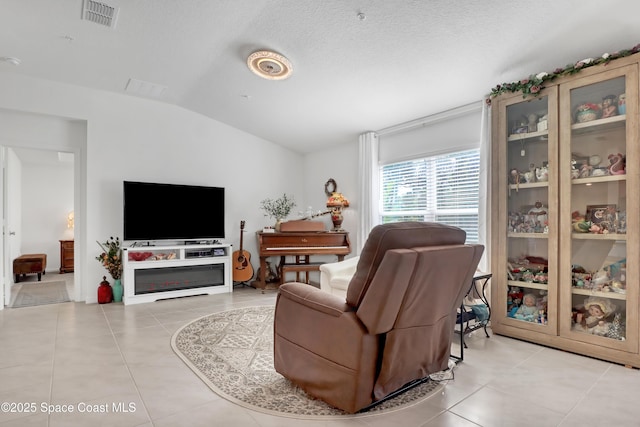 living room featuring light tile patterned floors, a textured ceiling, and lofted ceiling