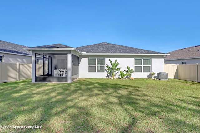 rear view of house featuring a sunroom, cooling unit, and a lawn