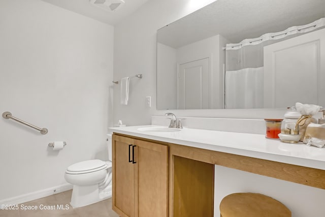 bathroom with tile patterned flooring, vanity, and toilet