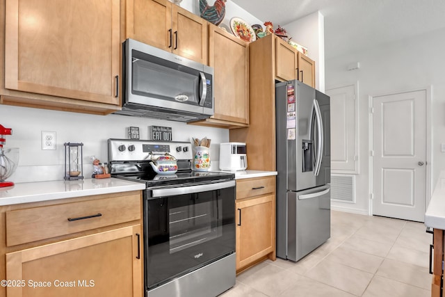 kitchen featuring light tile patterned flooring and stainless steel appliances