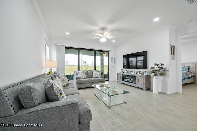 living room featuring ceiling fan, ornamental molding, and hardwood / wood-style flooring