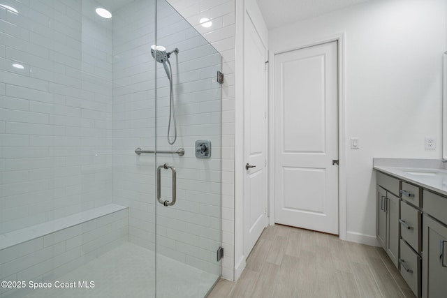 bathroom featuring wood-type flooring, vanity, and an enclosed shower