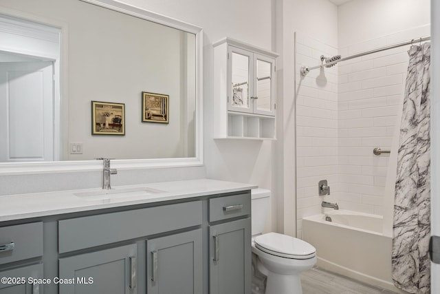 full bathroom with shower / bath combo with shower curtain, vanity, wood-type flooring, and toilet