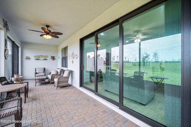 sunroom featuring ceiling fan and plenty of natural light