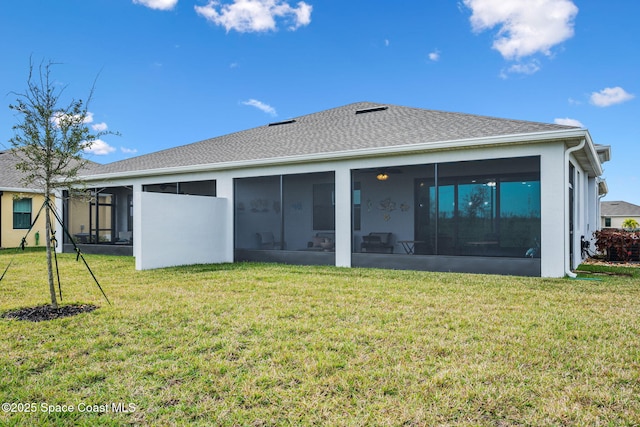 rear view of house featuring a sunroom and a lawn