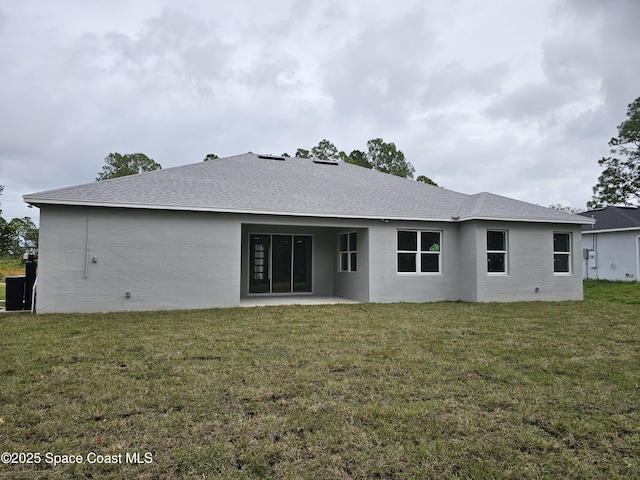 rear view of property featuring a patio area and a lawn