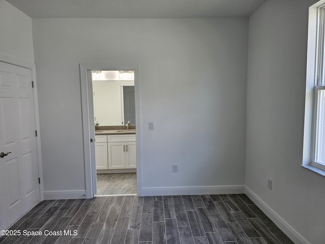 unfurnished bedroom featuring sink and ensuite bathroom