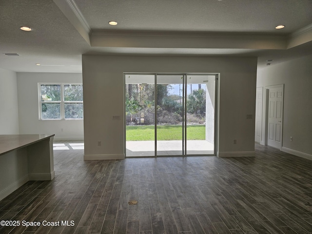 unfurnished living room featuring a textured ceiling, ornamental molding, dark hardwood / wood-style floors, and a tray ceiling