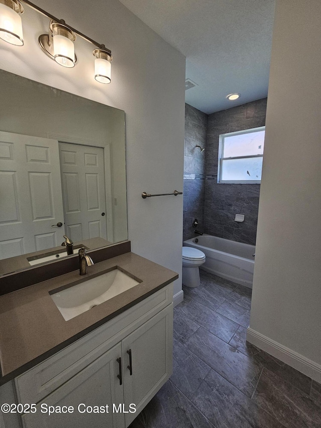 full bathroom with toilet, vanity, and tiled shower / bath