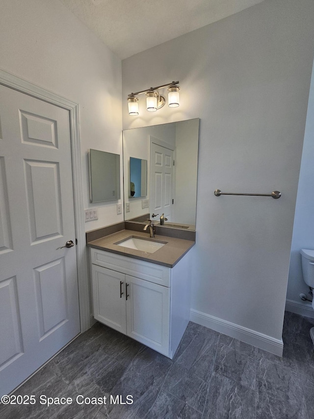 bathroom featuring toilet and vanity