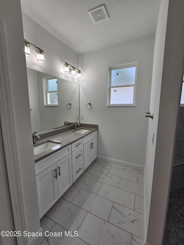 bathroom with a textured ceiling and vanity