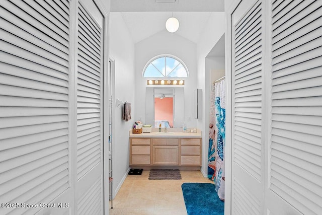 bathroom featuring tile patterned floors, vanity, lofted ceiling, and a shower with shower curtain