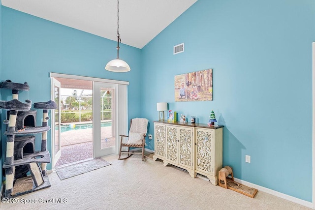 living area featuring carpet flooring and high vaulted ceiling