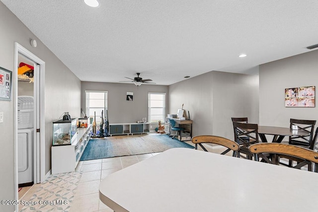 interior space with ceiling fan, light tile patterned floors, and a textured ceiling