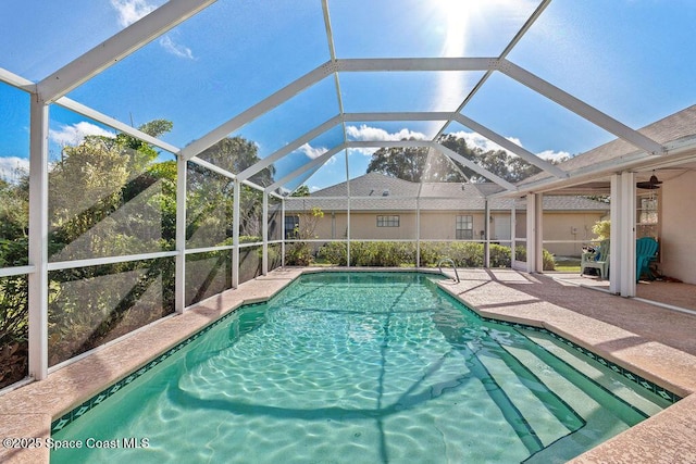 view of pool with glass enclosure and a patio area