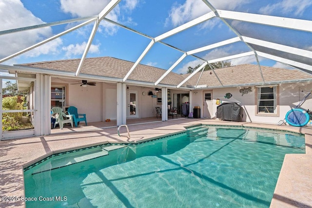 view of swimming pool with a lanai, a patio area, ceiling fan, and grilling area