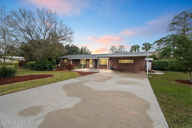 ranch-style house with a carport and a lawn