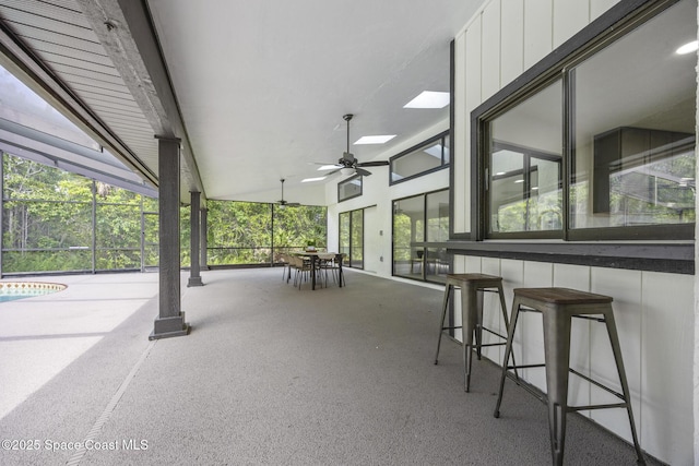 view of patio featuring ceiling fan and a bar