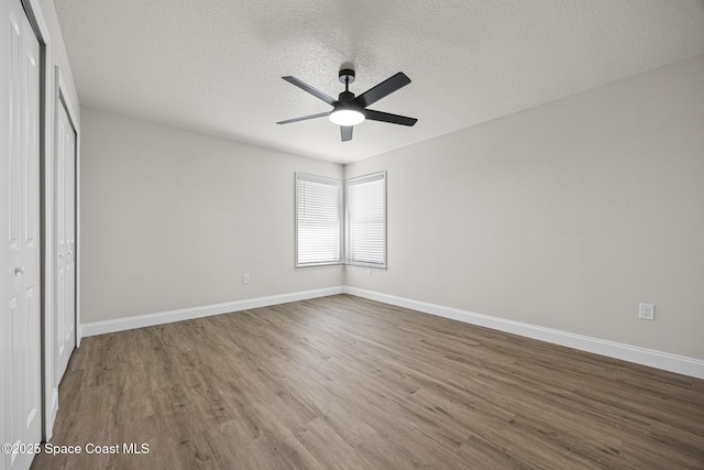 unfurnished bedroom featuring ceiling fan, a closet, wood-type flooring, and a textured ceiling