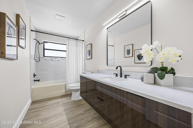 full bathroom with vanity, shower / bath combination with curtain, toilet, a textured ceiling, and wood-type flooring