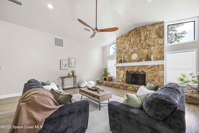 living room with a fireplace, light hardwood / wood-style flooring, and ceiling fan