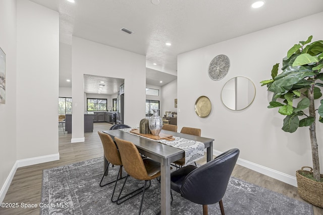 dining space featuring dark hardwood / wood-style floors and a textured ceiling