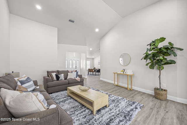 living room featuring wood-type flooring and lofted ceiling