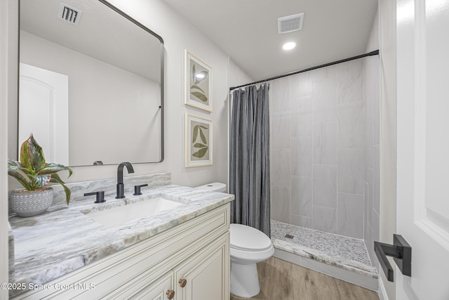 bathroom featuring vanity, hardwood / wood-style flooring, toilet, and curtained shower