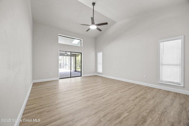 empty room with ceiling fan, light hardwood / wood-style flooring, and high vaulted ceiling