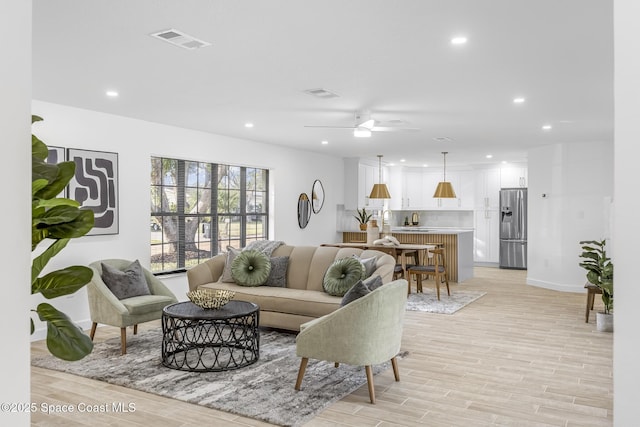 living room featuring ceiling fan and light wood-type flooring