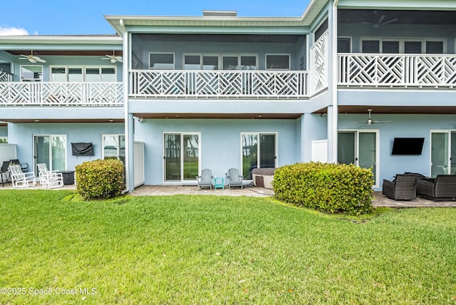 back of house with a sunroom, outdoor lounge area, ceiling fan, a yard, and a patio area